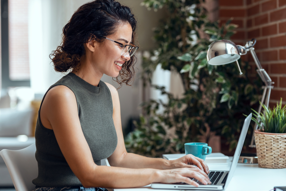 Woman working on laptop to maximize your linkedin presence.