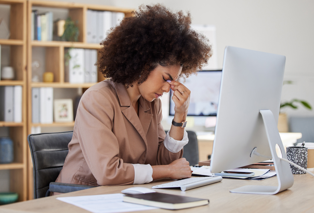 frustrated woman at laptop trying to write content for her ideal client.