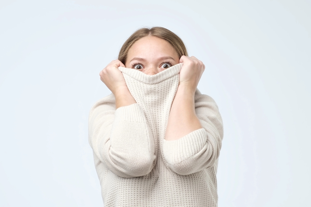 Introverted entrepreneur hiding under sweater