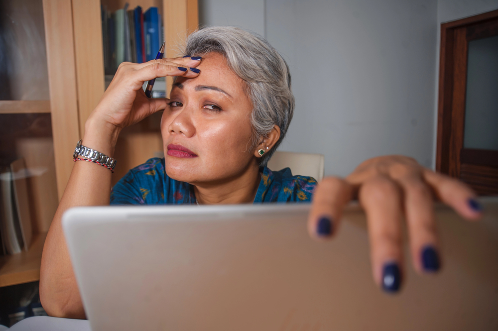 Overwhelmed woman closing laptop